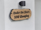 Personalised oak house sign mounted on white exterior wall with modern black light above