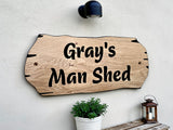 Man shed personalised oak sign mounted on exterior wall with plant decor