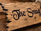 Detailed view of precision CNC carved lettering and hand-finished burnt edge on a solid oak sign.