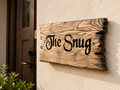 Personalised solid oak house sign with rustic burnt edges mounted beside a front door.