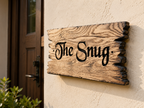 Personalised solid oak house sign with rustic burnt edges mounted beside a front door.