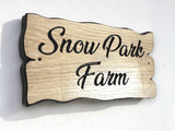 Personalised oak house sign Snow Park Farm mounted on exterior wall, engraved wooden name plaque with black lettering