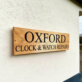 Personalised oak business sign mounted on exterior rendered wall in the UK