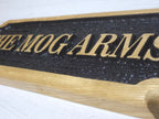 Close-up detail of engraved and painted raised letters on oak plaque