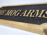 Close-up detail of engraved and painted raised letters on oak plaque