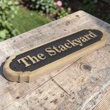 Custom wooden outdoor sign displayed on rustic garden table