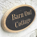 Personalised oval solid oak house sign mounted on exterior wall