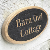 Personalised oval solid oak house sign mounted on exterior wall