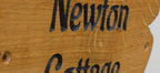 Close-up of engraved personalised solid oak cottage sign showing natural wood grain and precision laser engraving
