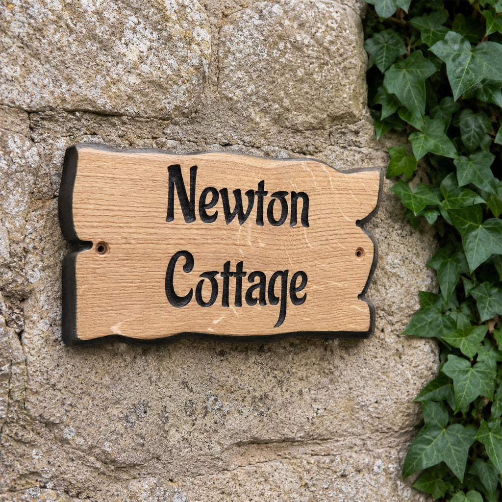 Engraved solid oak cottage name sign fixed to a stone wall with pre-drilled fixing holes