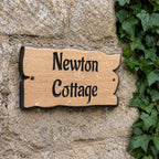 Engraved solid oak cottage name sign fixed to a stone wall with pre-drilled fixing holes