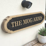 Angled view of personalised solid oak house name sign mounted on exterior wall