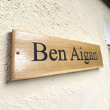 Wooden sign with 'Ben Aigan' engraved on a textured wall.