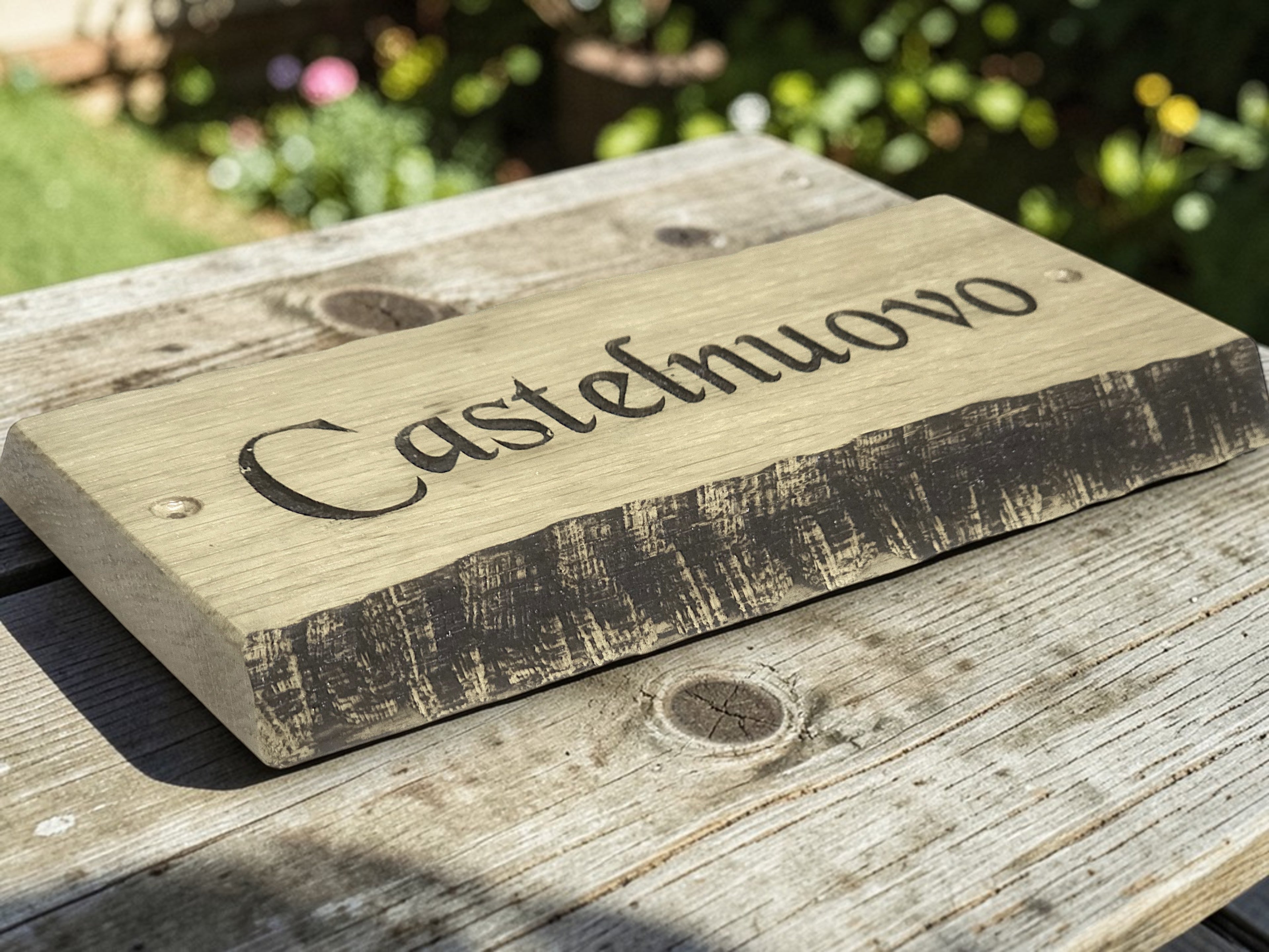 Handcrafted oak house name sign displayed on rustic wooden table lifestyle photography UK