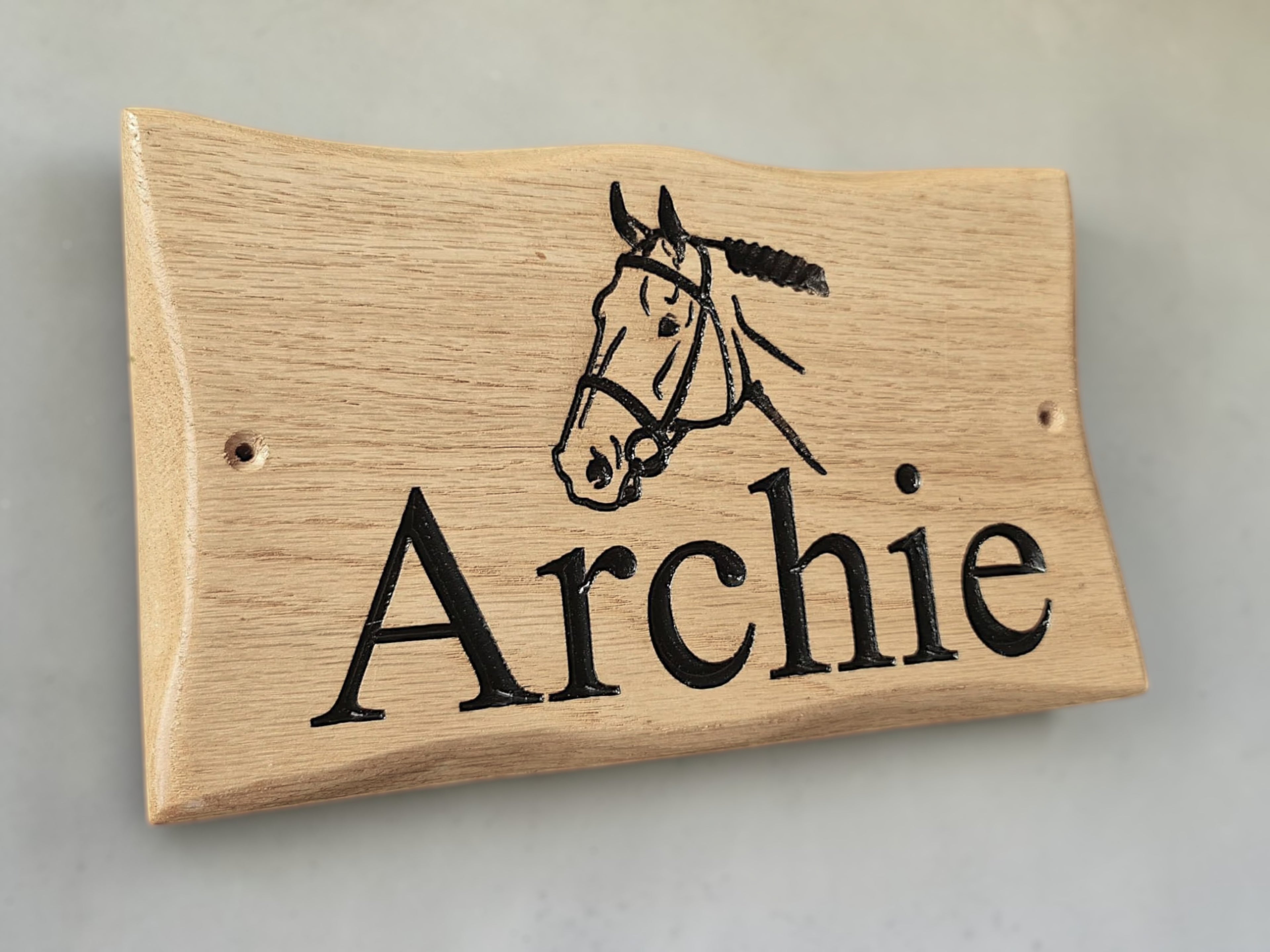 Side view of handcrafted oak animal name plaque showing wood grain detail