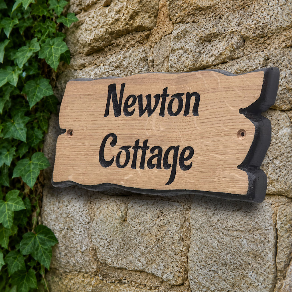 Side view of engraved solid oak cottage name plaque showing natural live edge profile