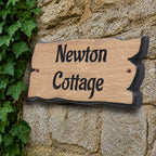 Side view of engraved solid oak cottage name plaque showing natural live edge profile
