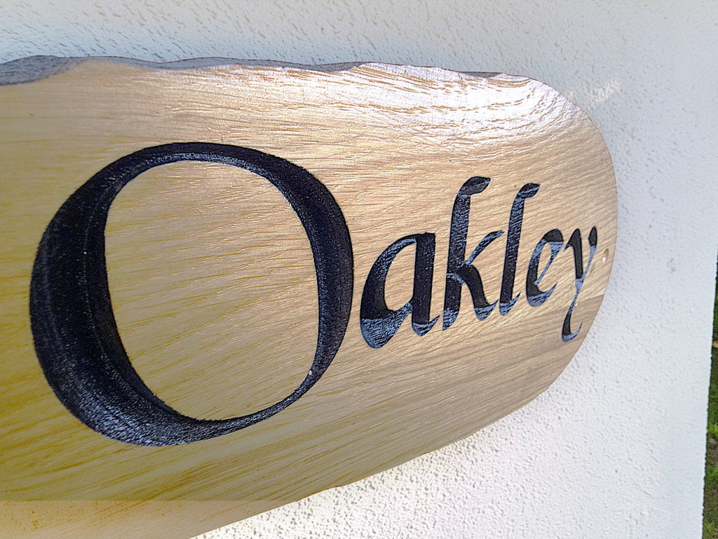 Close up detail of engraved oak house sign lettering Oakley