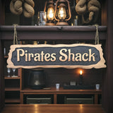 Wooden sign with 'Pirates Shack' text in a rustic interior setting.