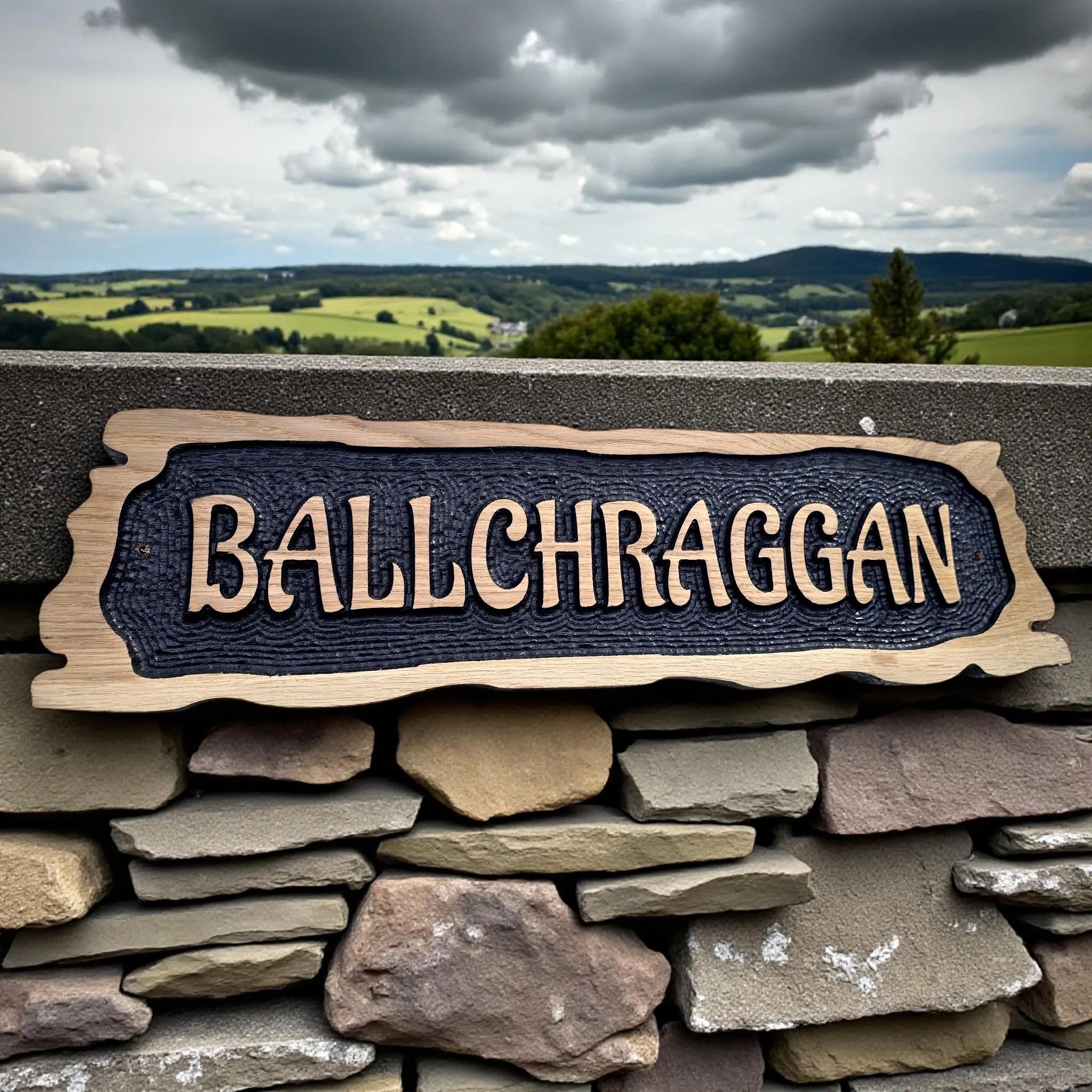 Ballchraggon rustic oak house sign displayed on stone wall