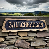 Ballchraggon rustic oak house sign displayed on stone wall