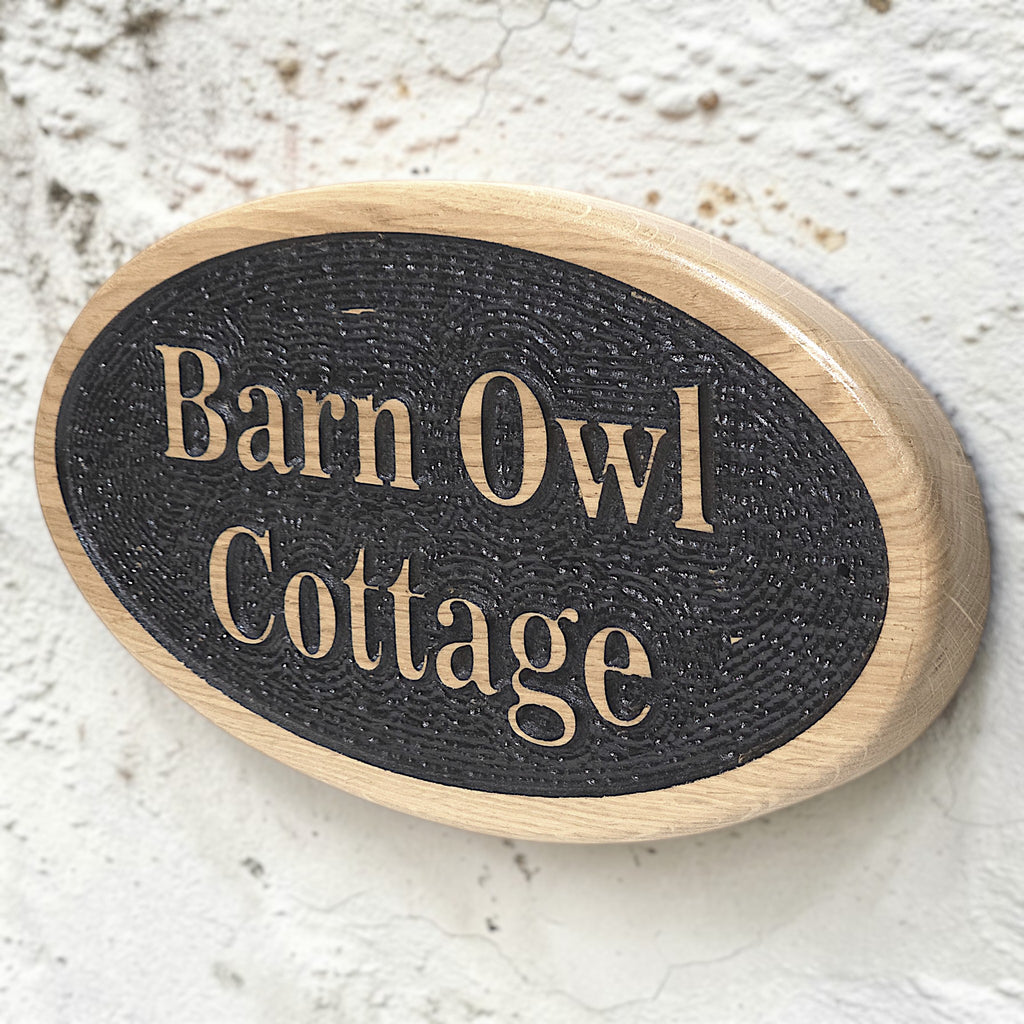 Personalised oval cottage sign mounted on rendered wall