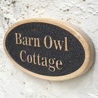 Personalised oval cottage sign mounted on rendered wall