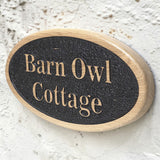 Personalised oval cottage sign mounted on rendered wall
